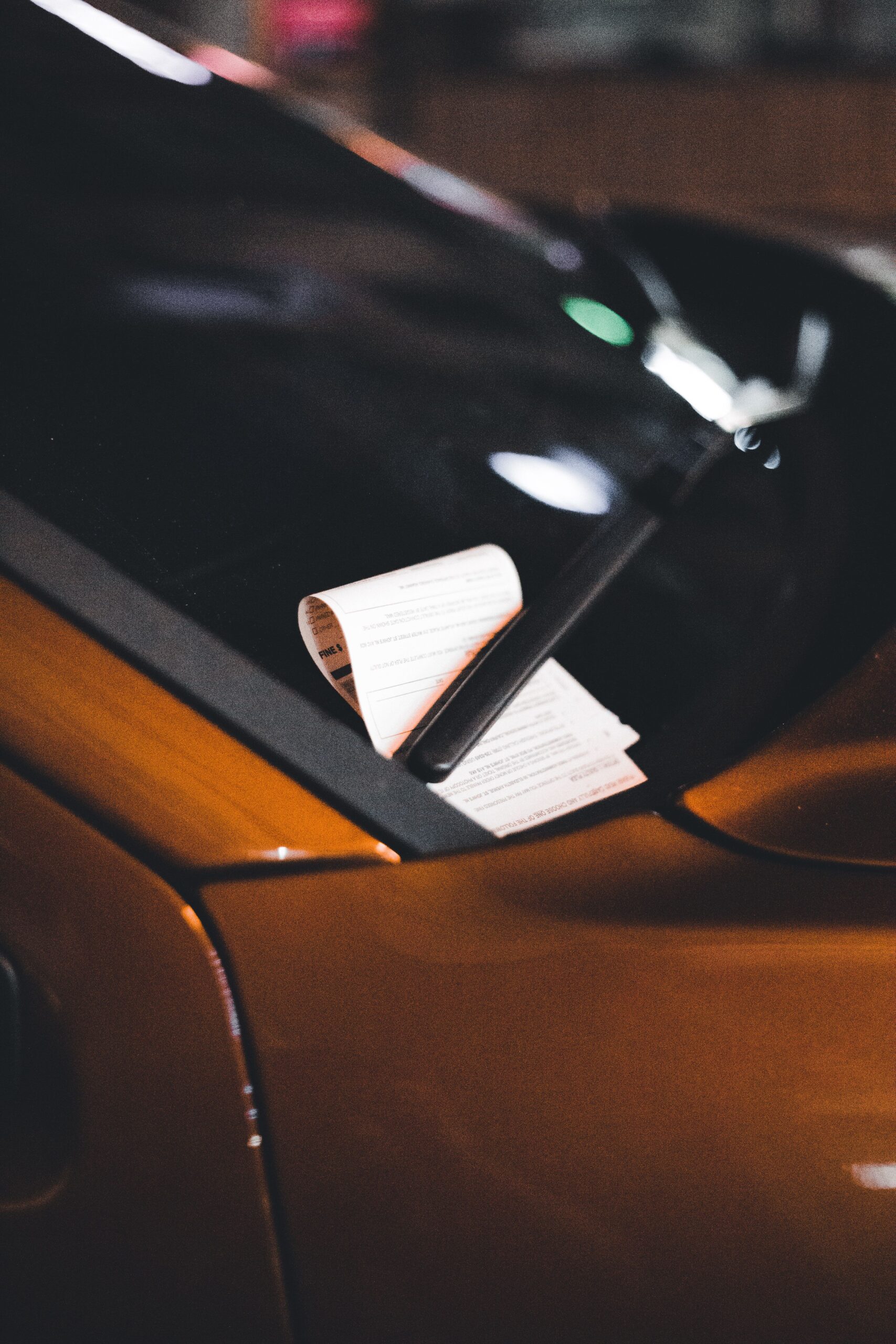 A speeding ticket left under a windshield wiper